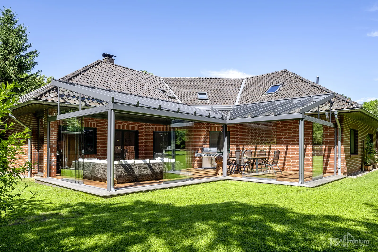 Sommergarten über Eck an einem Klinkerhaus mit Blick über den Rasen