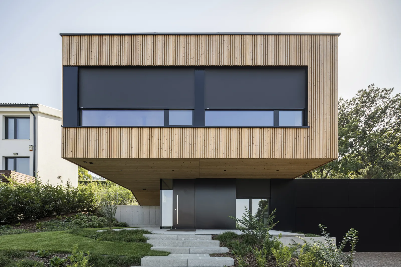 Senkrechtmarkisen an einem holzverkleideten Haus