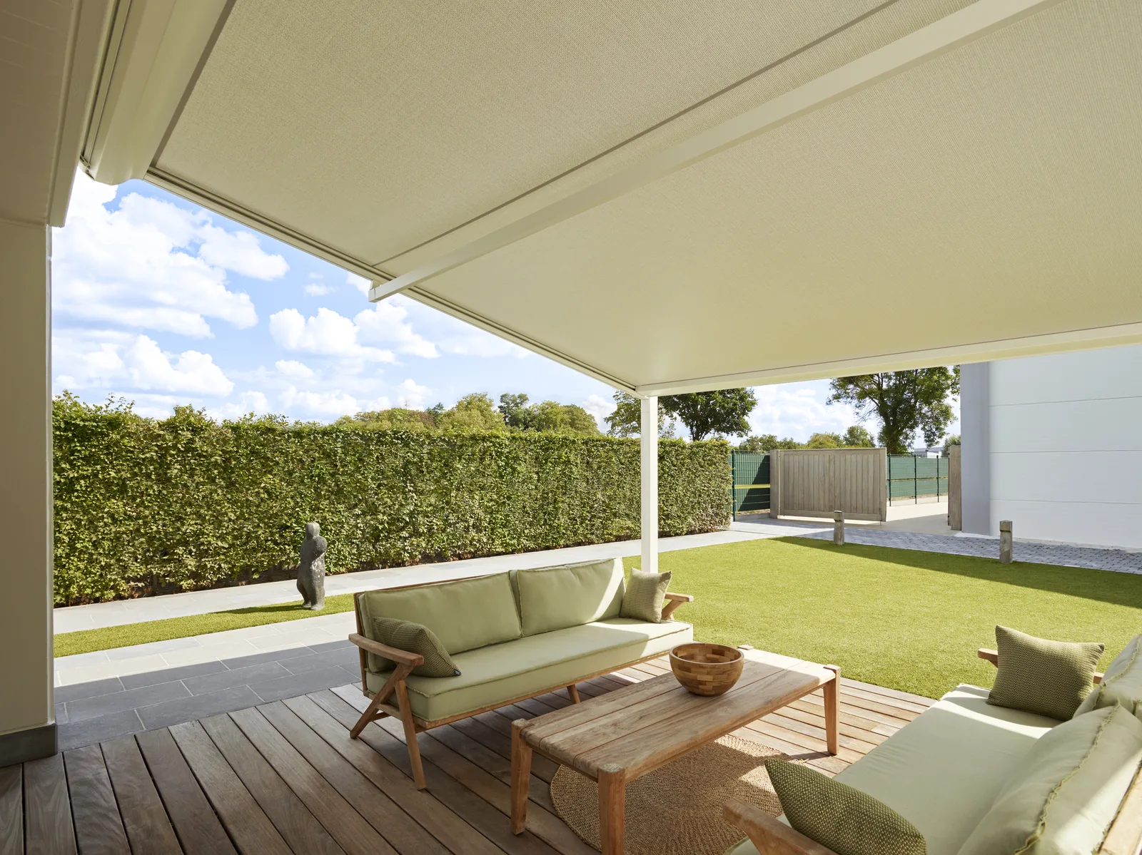 Pergola-Markise über einer Terrasse mit Sitzbereich am Rasen