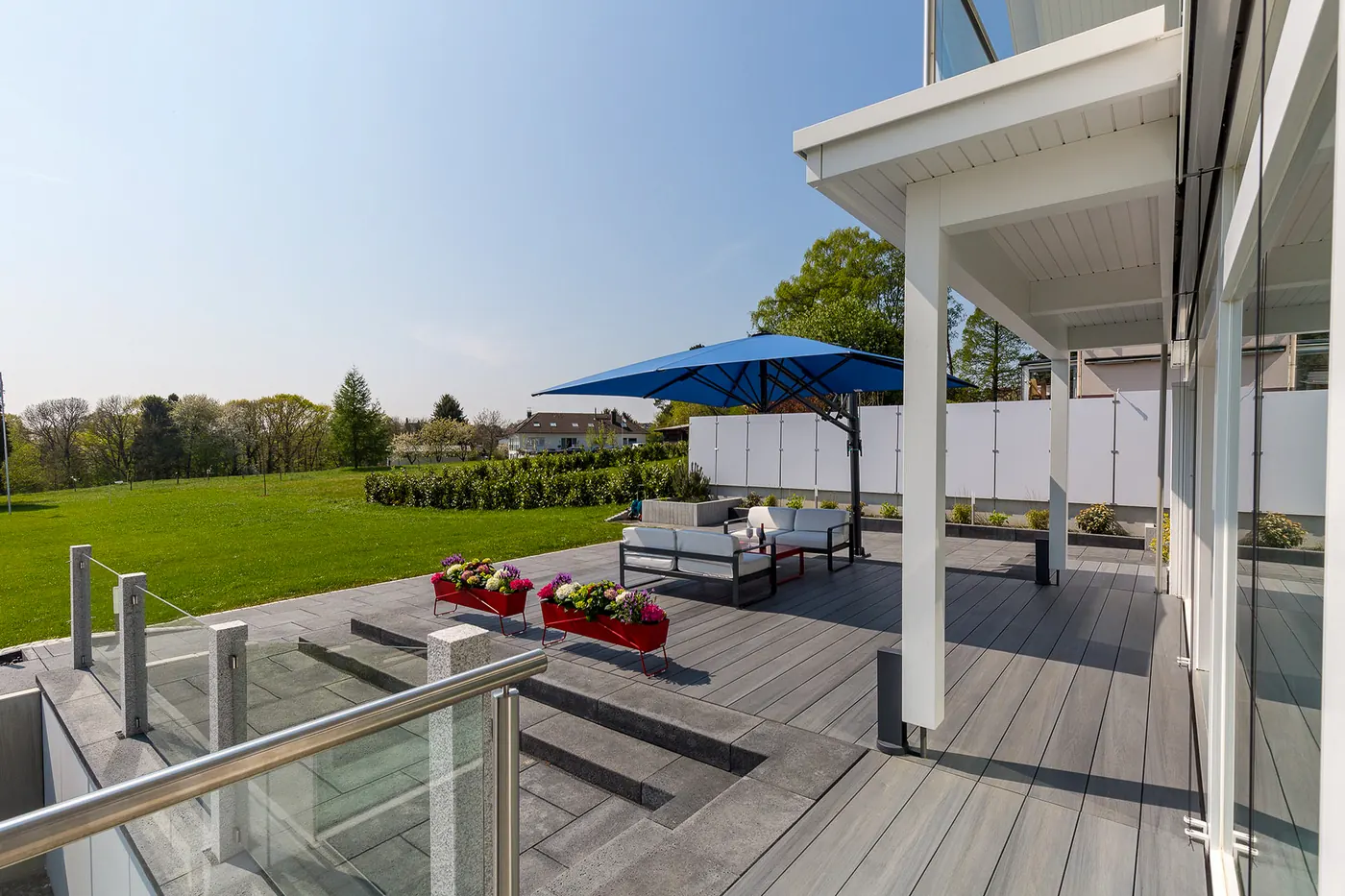 Freiarmschirm über einer überdachten Terrasse mit Loungebereich