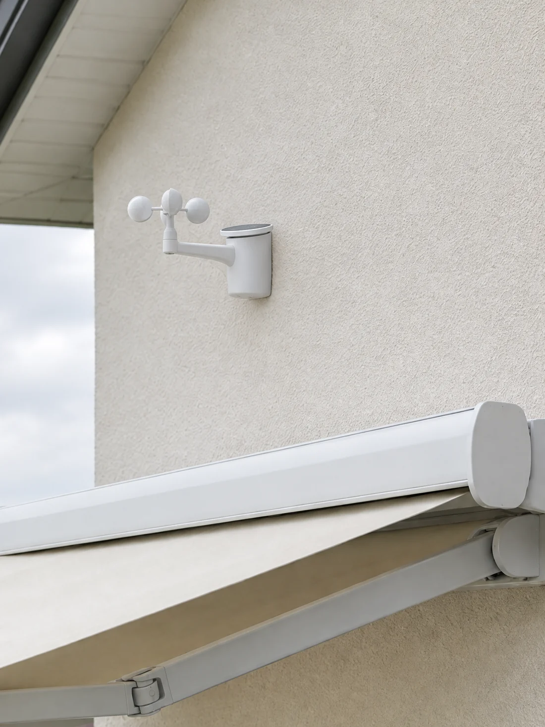 Wind- und Regenwächter an der Hauswand oberhalb einer Kassettenmarkise